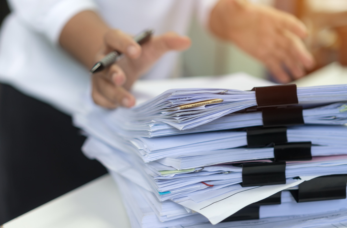 A stack of bundled paper on a table can be seen in the foreground.